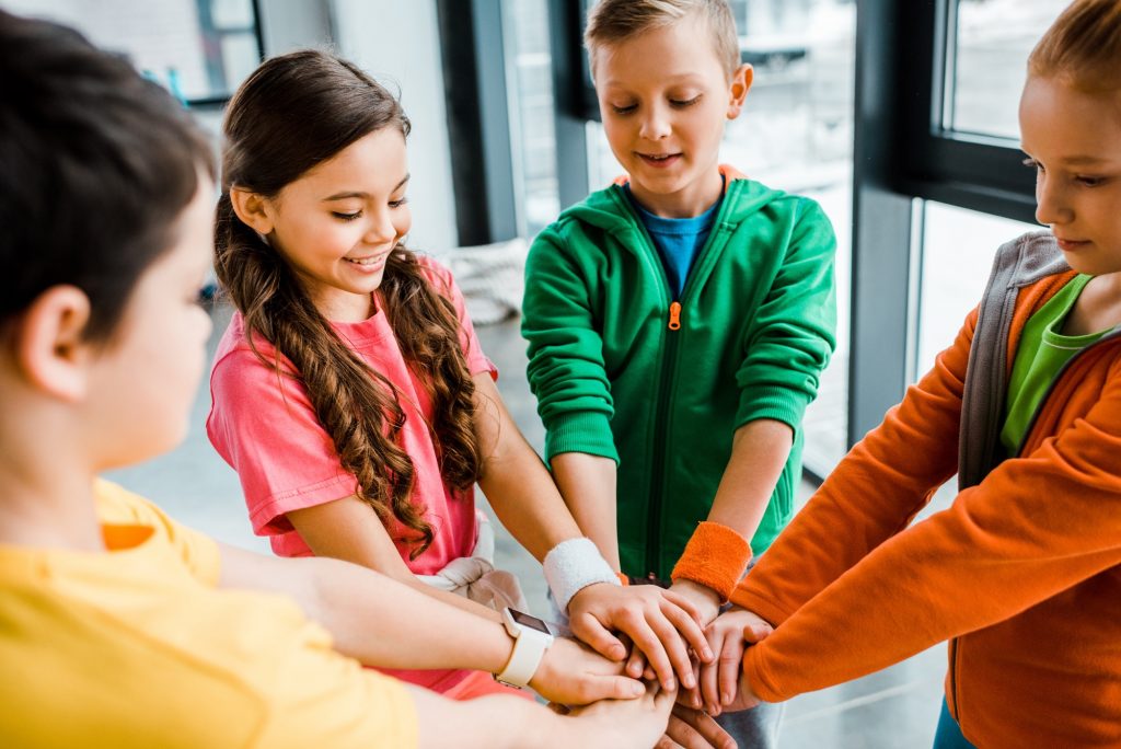 Group of kids preparing for sport competition and holding hands